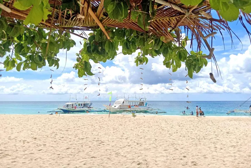 Snorkelers swimming over coral near Crystal Cove on a Boracay island hopping tour in the Philippines